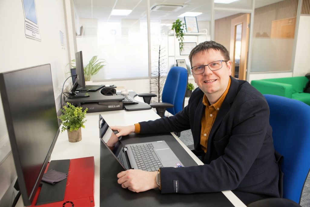 An Information Solutions team member working on a laptop in the Shrewsbury office